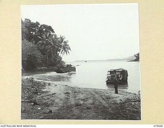 LAUNCH JETTY, FINSCHHAFEN, NEW GUINEA. 1944-01. A DUKW AMPHIBIOUS VEHICLE (BACKGROUND), USED BY THE 10TH FIELD AMBULANCE, AUSTRALIAN ARMY MEDICAL CORPS TO LOAD PATIENTS FROM THE ADVANCED DRESSING ..
