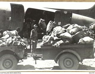 DUMPU, NEW GUINEA. 1943-12-19. SOME OF THE 500 BAGS OF MAIL FOR THE AUSTRALIAN TROOPS IN THE AREA BEING UNLOADED FROM AIRCRAFT AT THE DUMPU AIRSTRIP