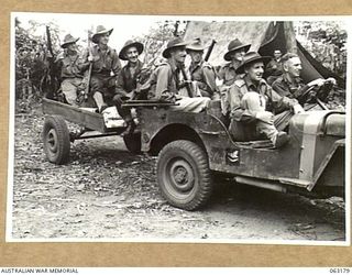 RAMU VALLEY, NEW GUINEA. 1944-01-01. MEMBERS OF THE 7TH DIVISION CONCERT PARTY IN THEIR JEEP AND TRAILER