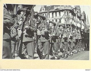MELBOURNE, VICTORIA. 1944-09-29. AUSTRALIAN TROOPS, VETERANS OF THE KOKODA TRAIL, GIVE AN "EYES RIGHT" AS THEY PASS THE SALUTING BASE DURING THE SECOND VICTORY LOAN MARCH THROUGH THE STREETS OF THE ..