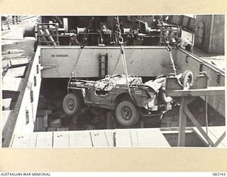 TOWNSVILLE, QLD. 1944-10-18. JEEPS BEING LOADED TWO AT A TIME BY ELECTRIC CRANE INTO HOLDS ABOARD THE LIBERTY SHIP SS JAMES OLIVER DURING EMBARKATION OF FIRST ARMY TO LAE, NEW GUINEA