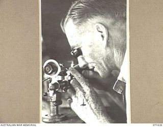 LAE, NEW GUINEA. 1944-03-24. SX4584 CRAFTSMAN N. A. MOORE, A CRAFTSMAN WATCHMAKER USING A WATCHMAKER'S LATHE IN THE MOBILE WORKSHOP AT THE 2/125TH BRIGADE WORKSHOP ATTACHED TO THE 7TH DIVISION