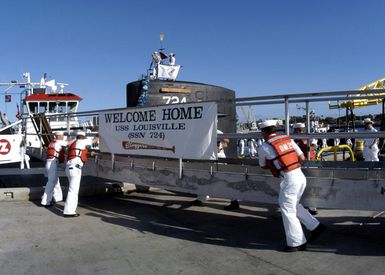 US Navy (USN) Sailors assigned to the line handling crew aboard the LOS ANGELES CLASS: Attack Submarine USS LOUISVILLE (SSN 724), make ready the gangway as crewmembers prepare to come ashore at Naval Base Pearl Harbor, Hawaii (HI), following an 8-month deployment in support of Operation IRAQI FREEDOM