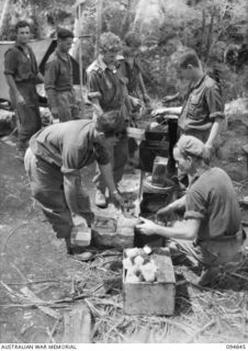 ILIPEM, NEW GUINEA, 1945-07-31. TROOPS OF 10 PLATOON, 2/5 INFANTRY BATTALION, ATTENDING A MESS PARADE AT A KITCHEN IN A FORWARD AREA. ALL FOOD IS DROPPED BY KAI BOMBERS AND OFTEN PREPARED WITH THE ..