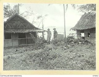 FINSCHHAFEN, NEW GUINEA. 1944-07-31. NX142659 MAJOR E.S. COX, 19TH LINES OF COMMUNICATION SIGNALS (1) AND WARRANT OFFICER II, D.W. MARTIN, HISTORY SECTION (2) AT THE OLD SIGNAL CAMP