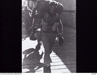 SYDNEY, NSW. 1946-05-09. NX173455 DRIVER W. C. SAMUELS RETURNING HOME, ONE OF THE MANY TROOPS WHOSE SOUVENIRS INCLUDED A JAPANESE SWORD, AFTER DISEMBARKING FROM THE TROOPSHIP DUNTROON, AT CIRCULAR ..