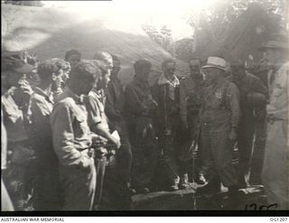 HOLLANDIA, DUTCH NEW GUINEA. C. 1944-06. WING COMMANDER W. D. BROOKES (RIGHT), MINISTER FOR AIR, ARTHUR DRAKEFORD (IN HAT), AND MINISTER FOR WAR ORGANISATION OF INDUSTRY, JOHN DEDMAN TALKING TO ..