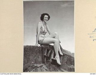 LAE, NEW GUINEA, 1945-05-18. LANCE-CORPORAL B.M. TERRY, AUSTRALIAN WOMEN'S ARMY SERVICE BARRACKS, ON THE END OF A DERELICT JAPANESE BARGE AT MALAHANG BEACH DURING A TOUR CONDUCTED BY ARMY AMENITIES ..