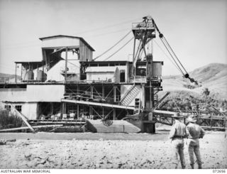 WAU - BULOLO ROAD, NEW GUINEA. 1944-04-26. A DREDGE OWNED BY THE BULOLO GOLD MINING COMPANY STANDS UNUSED 6 MILES FROM SUNSHINE AFTER BEING RENDERED USELESS BY AUSTRALIAN COMMANDOS DURING THE ..