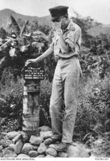 MILNE BAY, PAPUA. THIS PHOTOGRAPH SHOWS FLYING OFFICER HARRY TAYLOR OF THE RAAF, THEN OFFICER IN CHARGE OF TURNBULL FIELD, STANDING ON A PILE OF STONES BESIDE THE MEMORIAL TO THE MEN WHO DIED IN ..