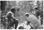 Men and boys eat a sacrificial meal in a shrine