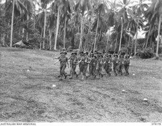 SIAR, NEW GUINEA. 1944-06-22. PERSONNEL OF NO.15 PLATOON, C COMPANY, 57/60TH INFANTRY BATTALION MOVING OFF THE UNIT PARADE GROUND AFTER THE MORNING PARADE. IDENTIFIED PERSONNEL ARE:- VX17616 ..