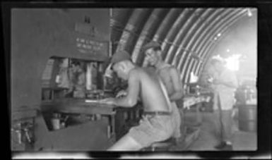 [Servicemen Palmer and Browning using band saw machine]