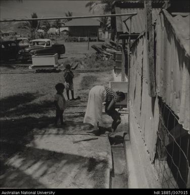 Woman washing child under tap