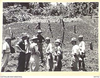 MUSCHU ISLAND, NEW GUINEA. 1945-10-10. MAJOR E.S. OWENS, ASSISTANT ADJUTANT AND QUARTERMASTER GENERAL, HEADQUARTERS 6 DIVISION, AND PARTY, WITH JAPANESE OFFICERS, INSPECTING THE NEWLY TILLED ..