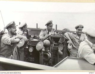 AT SEA. 1944-08-20. OFFICERS ON THE BRIDGE OF THE RAN FRIGATE, HMAS "BARCOO" DURING THE VESSEL'S RUN FROM SIAR TO POTSDAM WITH TROOPS OF THE 25TH INFANTRY BATTALION. THEY ARE:- LIEUTENANT A. GOTT, ..