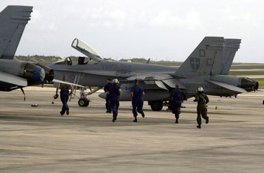 US Marine Corps (USMC) ground crews assigned to Marine Fighter Attack Squadron One Two Two (VMFA-122), scramble to launch their F/A-18C Hornet aircraft during exercise Jungle Shield, at Anderson Air Force Base (AFB) Guam