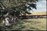 Group in a field outside a large building