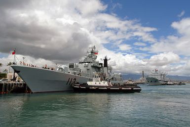 Tugboats assist two Chinese Peoples Liberation Army Navy ships, the Luhu (Type 052) Class Guided Missile Destroyer QINGDAO (DDG 113) (foregorund) and the Fuquing Class Replenishment Ship HONGZEHU (AOR 881) as they arrive at Naval Station Pearl Harbor, Hawaii, for a Goodwill Visit on Sept. 6, 2006. The visit provides an excellent opportunity to enhance cooperation between the two navies and underscores the United States commitment to supporting ongoing cooperative efforts in the Pacific Region. (U.S. Navy photo by CHIEF Mass Communication SPECIALIST Joe Kane) (Released)