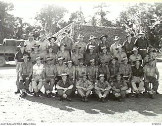 LAE, AREA, NEW GUINEA. 1944-11-18. PERSONNEL OF THE MOTOR TRANSPORT SECTION, NO.1 PLATOON, 2/7TH ADVANCED WORKSHOPS, NX169 CAPTAIN J. CROMIE, SECTION COMMANDER IS SEATED (CENTRE)