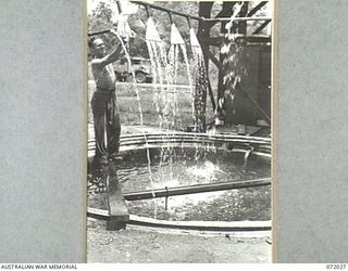 MILNE BAY, NEW GUINEA. 1944-04-04. VX114760 SAPPER I.L. ALLEN, 5TH ARMY TROOP COMPANY, ROYAL AUSTRALIAN ENGINEERS FITS A WATER SPRAY TO THE WATER COOLING SYSTEM. THE SYSTEM IS USED TO COOL MOTORS ..