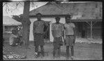 Three men in front of a building