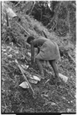 Woman works in garden on coastal slope