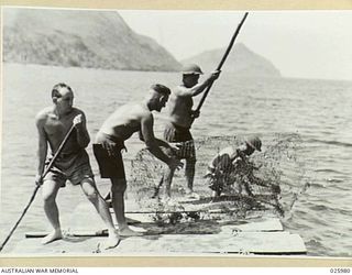 PORT MORESBY, PAPUA. 1942-07-20. PUNTING THEIR "LAKATOI", (NATIVE NAME FOR A SAILING CRAFT) THESE AUSTRALIAN SOLDIERS PUSH OUT THROUGH THE SHALLOWS ON A FISHING EXCURSION. THE NATIVE SAILING CRAFT ..