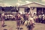 Men wearing conical masks, their bodies smeared with mud, reenact ritual dances for spirits at the Erave patrol post