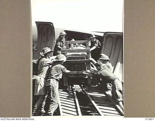 1942-11-19. NEW GUINEA. A BULDOZER BEING UNLOADED FROM A TRANSPORT PLANE. (NEGATIVE BY G. SILK)