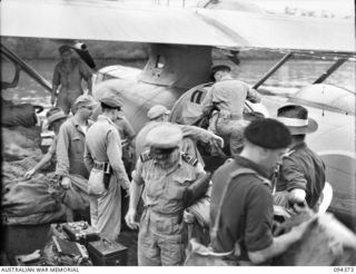 JACQUINOT BAY, NEW BRITAIN. 1945-07-26. AUSTRALIAN OFFICERS FROM HEADQUARTERS 11 DIVISION IN A BARGE ABOUT TO BOARD A CATALINA FOR THE TRIP TO WIDE BAY AND THEN OPEN BAY. AIR TRAVEL IS, AT THE ..