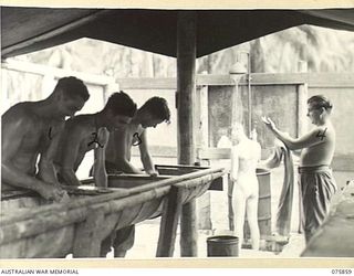 ALEXISHAFEN, NEW GUINEA. 1944-09-14. THE INTERIOR OF THE MEN'S SHOWERS AND LAUNDRY IN THE CAMP AREA OF THE 133RD BRIGADE ORDNANCE FIELD PARK. IDENTIFIED PERSONNEL ARE:- NX122311 CORPORAL A.B. ..