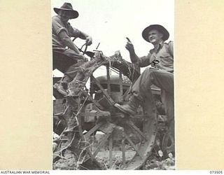 NARAKAPOR, NEAR NADZAB, NEW GUINEA. 1944-05-27. TP6620 LIEUTENANT K. A. JOHNSON (2), A TASMANIAN FARMER IN CIVILIAN LIFE, PASSES INSTRUCTIONS TO V240439 DRIVER S. F. JARDINE (1), WHO OPERATES A ..