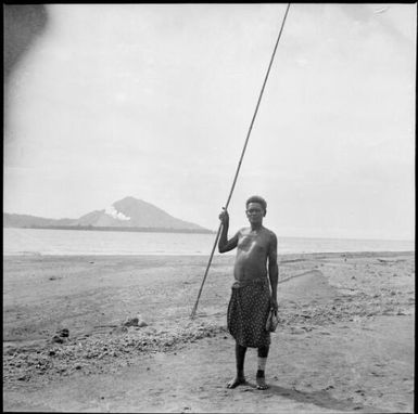 Man on a beach with a long handled fishing spear, Rabaul, New Guinea, 1937 / Sarah Chinnery
