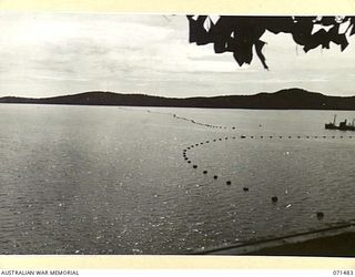 PORT MORESBY, PAPUA, NEW GUINEA, 1944-03-27. THE ANTI-SUBMARINE BOOM VIEWED FROM NO.13 DIRECTOR PEDESTAL AT PAGA BATTERY, COAST ARTILLERY INDICATING MEASURES TO PROTECT PORT MORESBY HARBOUR
