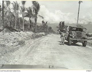 BOUGAINVILLE ISLAND. 1945-01-22. AUSTRALIAN ARMY TRUCK DRIVERS GIVE THE SIGNAL WITH THEIR MUGS FOR A CUP OF TEA AS THE JEEP TRAILER OF THE YOUNG MEN'S CHRISTIAN ASSOCIATION - AUSTRALIAN COMFORT ..