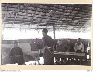 CAPE WOM, NEW GUINEA, 1945-12-01. LIEUTENANT K.J. PHILLIPS GIVING EVIDENCE AT THE TRIAL OF LIEUTENANT TAZAKI, WHO WAS CHARGED WITH AND LATER SENTENCED TO DEATH FOR CANNIBALISM, MUTILATING AND ..