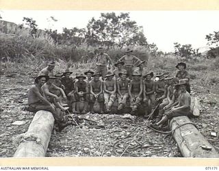 EVAPIA RIVER, NEW GUINEA, 1944-03-15. PERSONNEL OF NO.1 PLATOON, 2/4TH FIELD COMPANY, ROYAL AUSTRALIAN ENGINEERS, SEATED ON A SUPPORT TO THE SUSPENSION BRIDGE UNDER CONSTRUCTION ACROSS THE EVAPIA ..