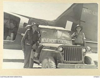 MADANG, NEW GUINEA. 1944-10-18. V310843 PRIVATE W.E. DAY (1) AND VX10345 CORPORAL T.G. MIDDLETON (2), 8TH MOVEMENT CONTROL GROUP AWAITING THE ARRIVAL OF AN AIRCRAFT AT THE LOCAL AIRSTRIP