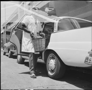 Man putting a cask of vino into a car, Noumea, New Caledonia, 1967 / Michael Terry