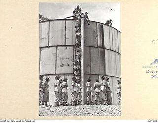 LAE, NEW GUINEA, 1945-05-18. PERSONNEL FROM THE AUSTRALIAN WOMEN'S ARMY SERVICE BARRACKS VIEW LAE HARBOUR FROM THE WATER TOWER ON TOP OF MOUNT LUNAMAN DURING AN ARMY AMENITIES TOUR AROUND THE AREA ..