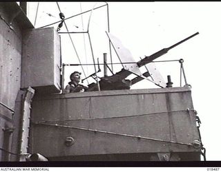 WEWAK AREA, NEW GUINEA. MAY 1945. SERGEANT A. G. CHARLTON OF CARLISLE, WA, MANS AN OERLIKON GUN ON BOARD HMAS DUBBO DURING AMPHIBIOUS TRAINING EXERCISES AT BUT