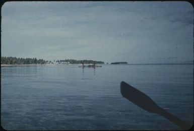 Islands of the atoll's ring, canoe in distance : Mortlock Islands, Papua New Guinea, 1960 / Terence and Margaret Spencer
