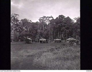 SOGERI, NEW GUINEA. 1943-11-04. PARADE GROUND AND BARRACKS OF THE JUNIOR LEADERS WING AT THE NEW GUINEA FORCE TRAINING SCHOOL. BARRACKS ARE BUILT IN NEW GUINEA STYLE