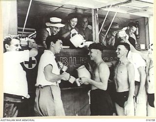 NEW GUINEA. 1943-11-19. RED CROSS WORK FROM A VAN AT A PICNIC FOR CONVALESCENTS OF AN AUSTRALIAN FIELD HOSPITAL. SISTER HOARE, MRS ALLEN, MRS SCHAEFER, MISS LARKE AND PTE. K. DORAN HAND OUT TEA AND ..