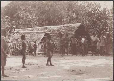 Villagers standing in front of buildings in Nerinignam, Mota Lava, Banks Islands, 1906 / J.W. Beattie