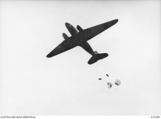 1943-08-03. NEW GUINEA. FOOD AND AMMUNITION FOR ALLIED TROOPS IN THE FORWARD AREA A MUBO BEING DROPPED FROM A TRANSPORT PLANE. THE CONTAINERS ARE ATTACHED TO PARACHUTES. (NEGATIVE BY G. SHORT)