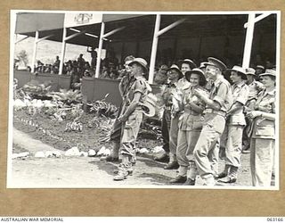 DONADABU, PAPUA, NEW GUINEA. 1944-01-01. THE GRANDSTAND AND PORTION OF THE CROWD AT THE 15TH INFANTRY BRIGADE GYMKHANA. IDENTIFIED PERSONNEL ARE: PRIVATE M. J. O'LOUGHLIN (1); VX102648 CAPTAIN C. ..