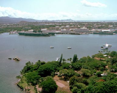 An overview of Ford Island, foreground, and Pearl Harbor, with the USS ARIZONA Memorial at right and the aircraft carriers USS MIDWAY (CV-41) and USS INDEPENDENCE (CV-62) moored beside each other in the background. The MIDWAY is en route from Naval Station, Yokosuka, Japan, to Naval Air Station, North Island, Calif., where it will be decommissioned in the spring of 1992. The INDEPENDENCE will travel to Yokosuka to take over as the Navy's forward-based aircraft carrier