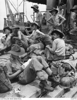 AT SEA IN THE ADMIRALTY ISLANDS AREA. 1944-03-18. RAAF AIRMEN ON THE DECK OF A LANDING CRAFT ON THE WAY TO THE ADMIRALTY ISLANDS. LEADING AIRCRAFTMAN G. EDSALL OF BRIGHTON, VIC, WRITES A LETTER ..